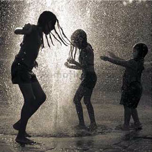 Niños jugando en un chorro de agua.