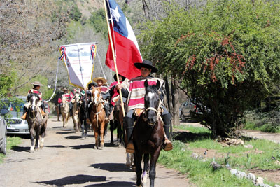 Grupo de ''Huasos'' a caballo con sus estandartes camino a la celebración.
