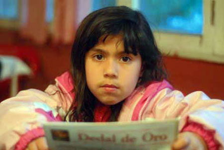 Josefa de seis años leyendo la revista Dedal de Oro.